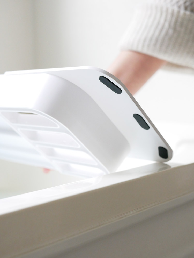 Yamazaki製の伸縮バスタブトレーが調節され、浴槽に取り付けられている様子