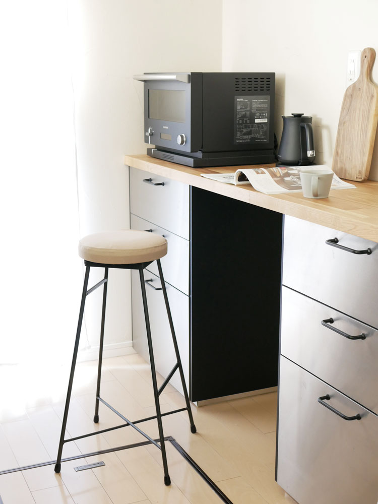 二色調のスツール、牛革とキャンバス素材の座面にクリアラッカー塗装された鉄製脚が特徴のモダンなデザイン。