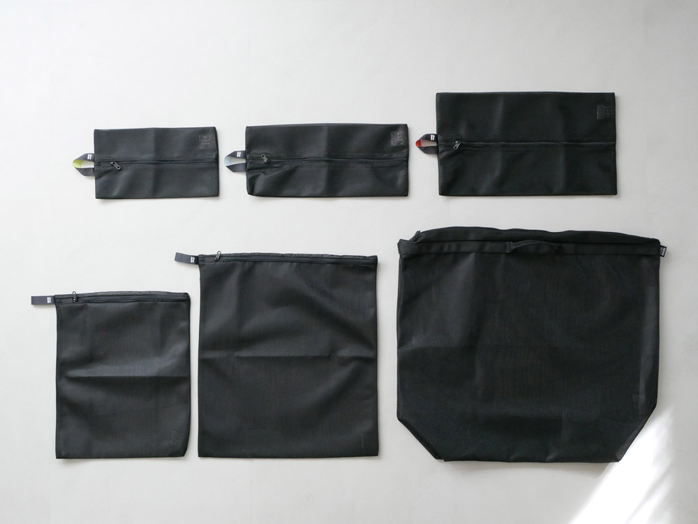 サラサデザインの「b2c ランドリーネット ワイド」を洗濯機内で衣類と共に使用している様子。ポリエステルとラテックス素材の幅広タイプ。