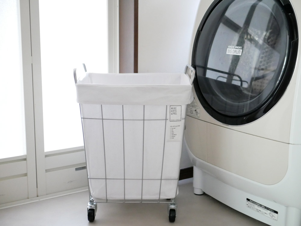 BRIDの白色スクエア型ランドリーストレージ45L。スチール製フレームにポリエステルとコットンの布袋が付いており、キャスター付きで移動可能な収納ボックス