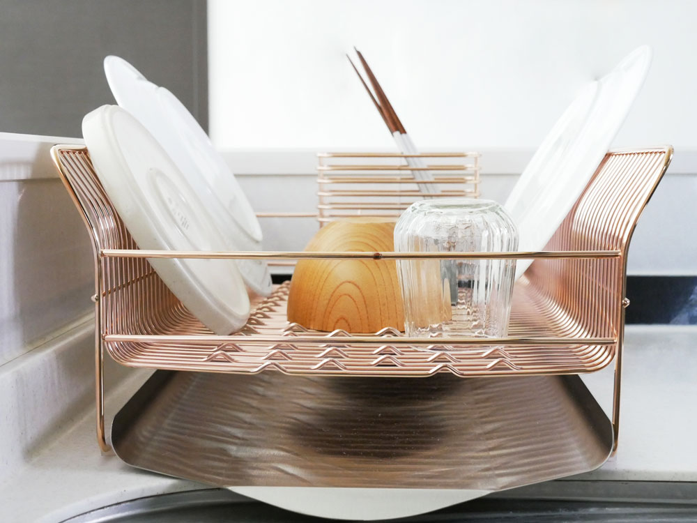 hanautaブランドのローズゴールドメッキ横置き水切りラック。ステンレス製の箸立てとトレイが付属し、キッチンで食器を乾かすために設置されています