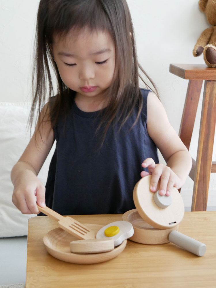 dou?ブランドのままごとがっき pop panセット。ビーチ材製のフライパンと卵、ハンバーグ、フライ返しが揃ったおもちゃキッチンの写真。