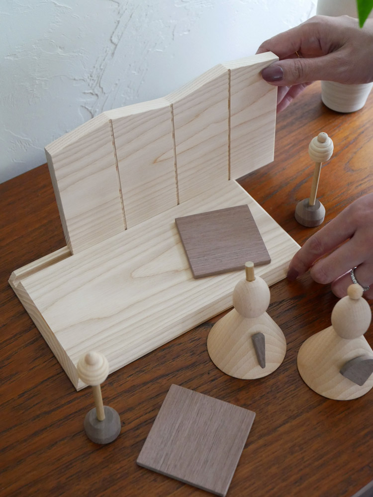 P.F WORK SHOPの木製お雛様。高さ12.5cm、横22cmで、自然な木目と伝統的な衣装を纏った小型の人形です。