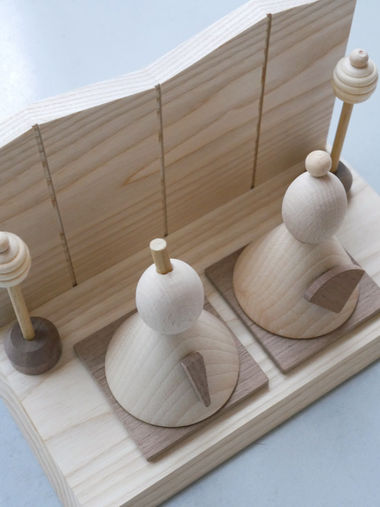 P.F WORK SHOPの木製お雛様セット。高さ約12.5cm、横約22cmで、伝統的なデザインの雛人形が並べられているインテリア用飾り物。
