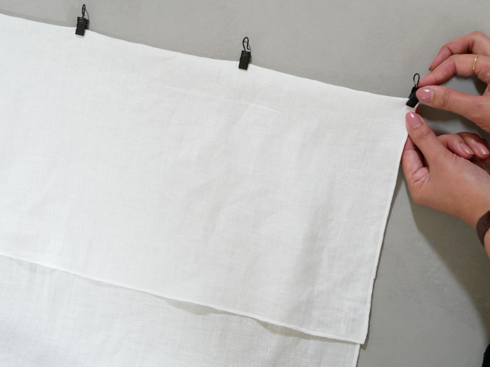 ナチュラルな白色の麻100％リネン製クリップ留めレースカーテン。四方メローロック仕立てで、シンプルなデザインが特徴です。