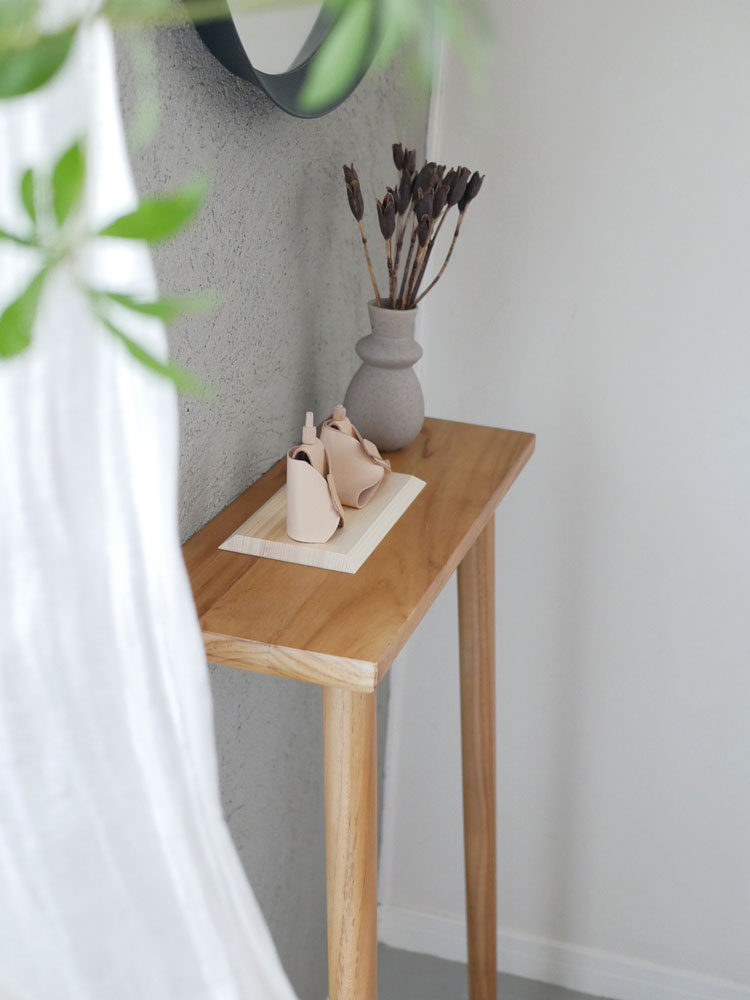 【Comore Sun】こどもと共に育つヌメ革のお雛様。ヌメ革の着物をまとったお内裏様とお雛様がヒノキの台座に並んで展示されています