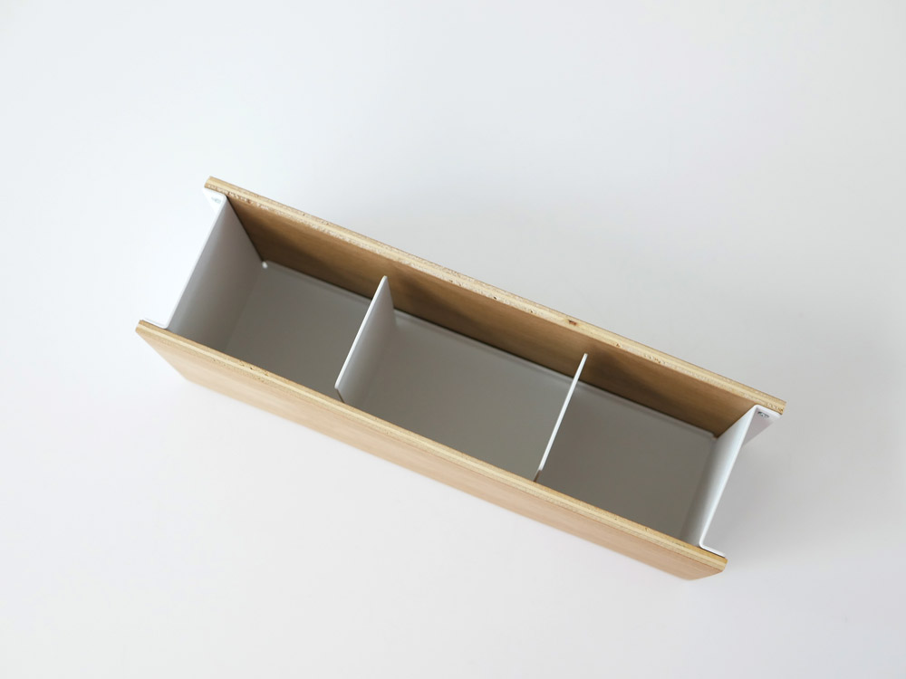 天然木とスチールで作られたペンとリモコンを収納するラック