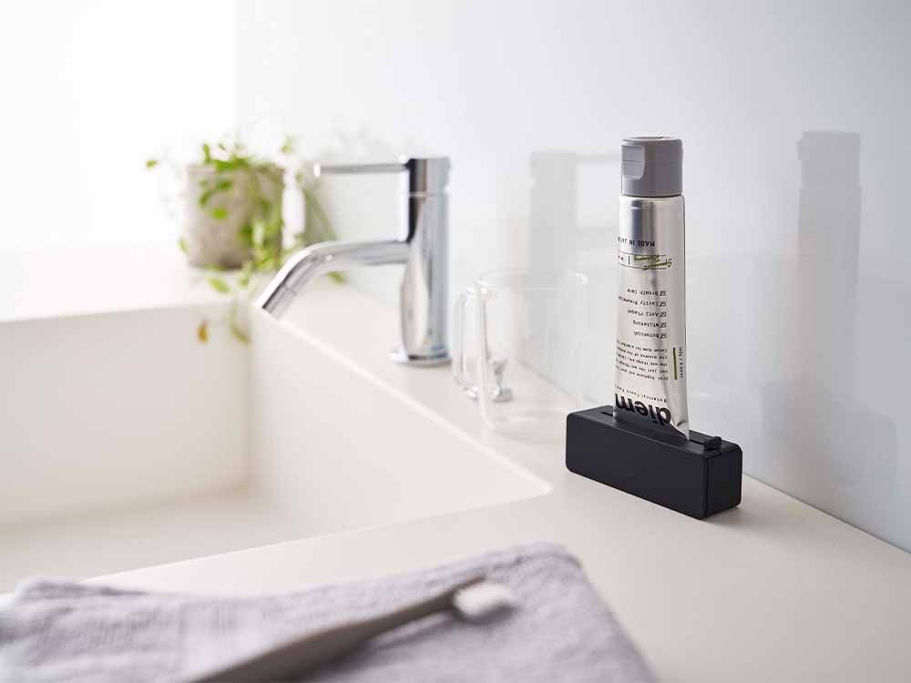 マグネット歯磨き粉ホルダーが浴室の壁に取り付けられている様子